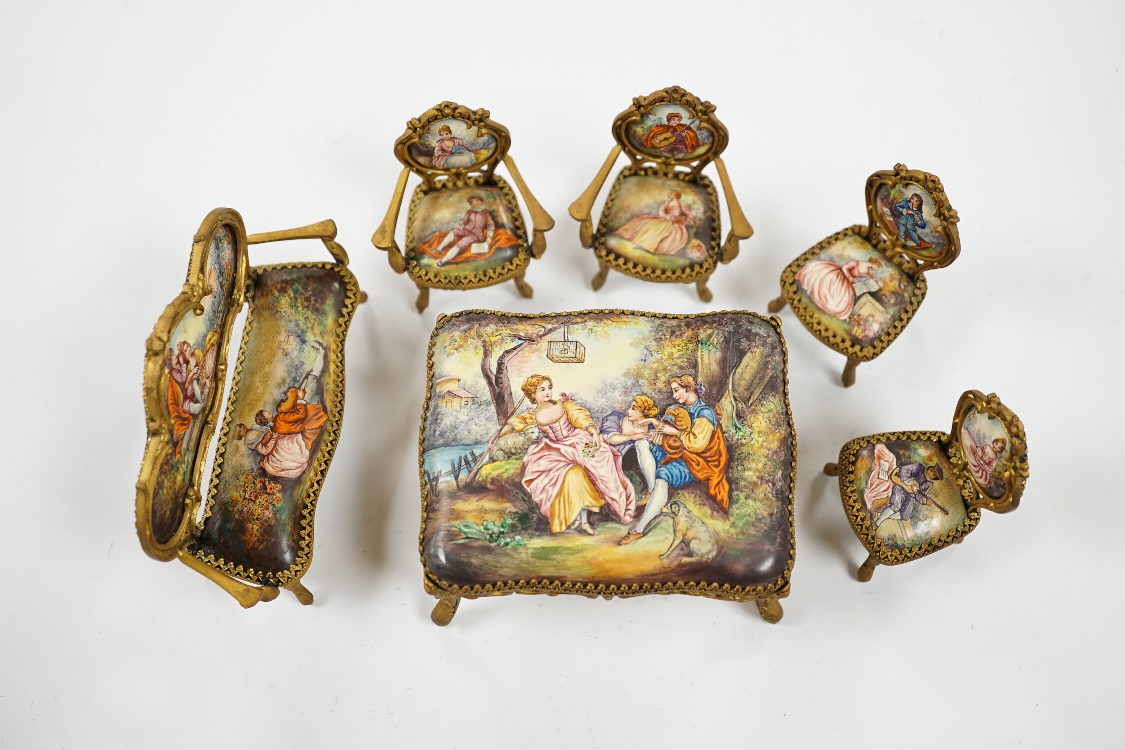 An early 20th century miniature enamel and gilt metal framed furniture set, possibly Austrian, largest 9cm wide. Condition - fair